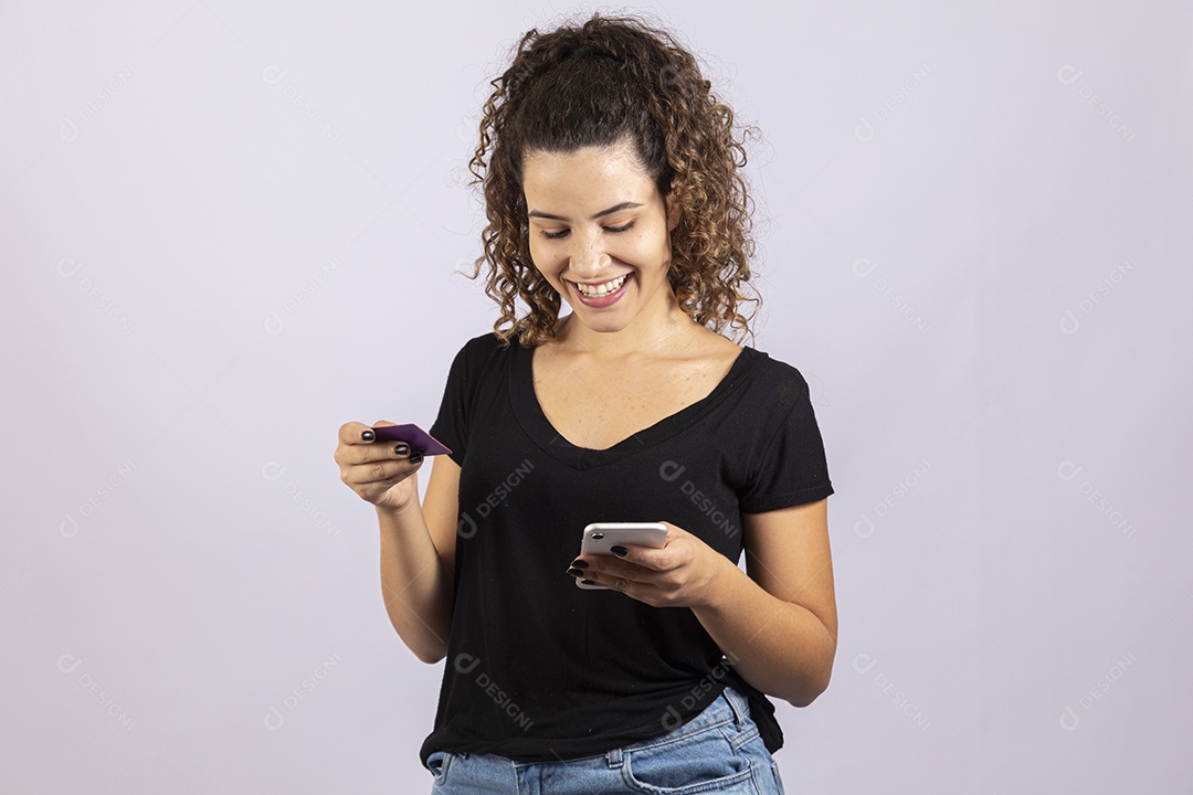 Linda mulher garota jovem segurando celular smartphone e cartão de crédito sobre fundo isolado