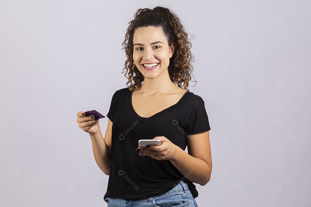 Linda mulher garota jovem segurando celular smartphone e cartão de crédito sobre fundo isolado