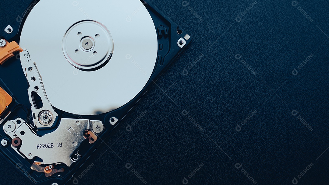 Unidade de disco rígido aberta desmontada HDD de computador ou laptop encontra-se na superfície fosca escura.