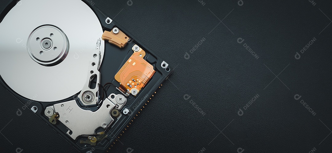 Unidade de disco rígido aberta desmontada HDD de computador ou laptop encontra-se na superfície fosca escura.