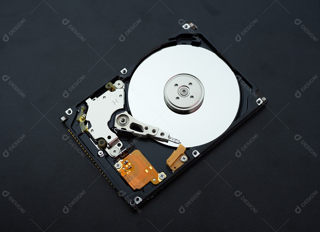 Unidade de disco rígido aberta desmontada HDD de computador ou laptop encontra-se na superfície fosca escura.