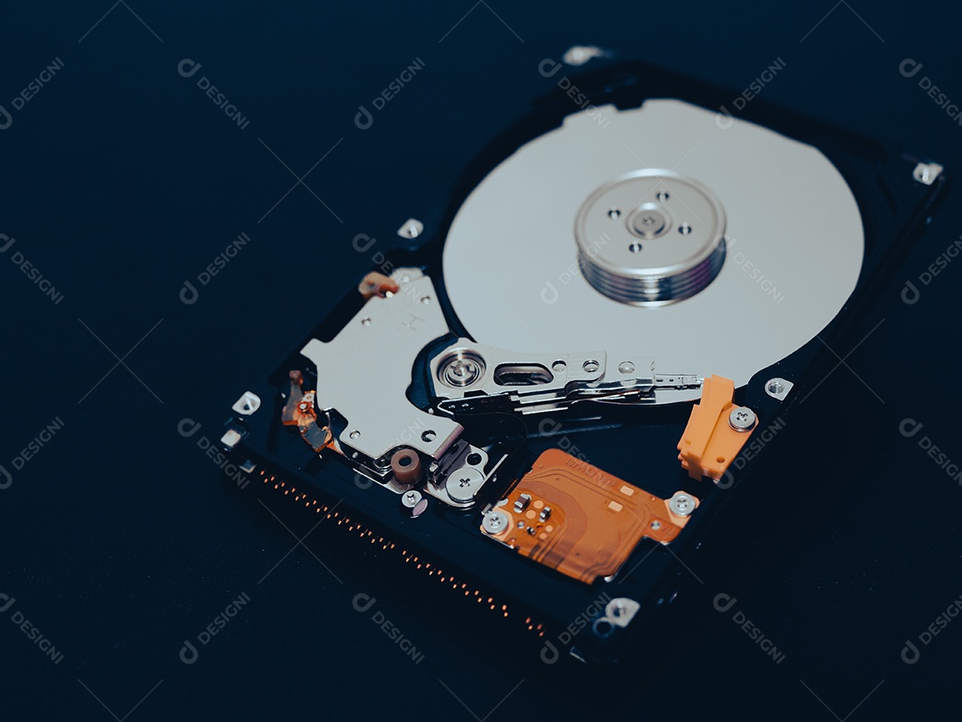 Unidade de disco rígido aberta desmontada HDD de computador ou laptop encontra-se na superfície fosca escura.