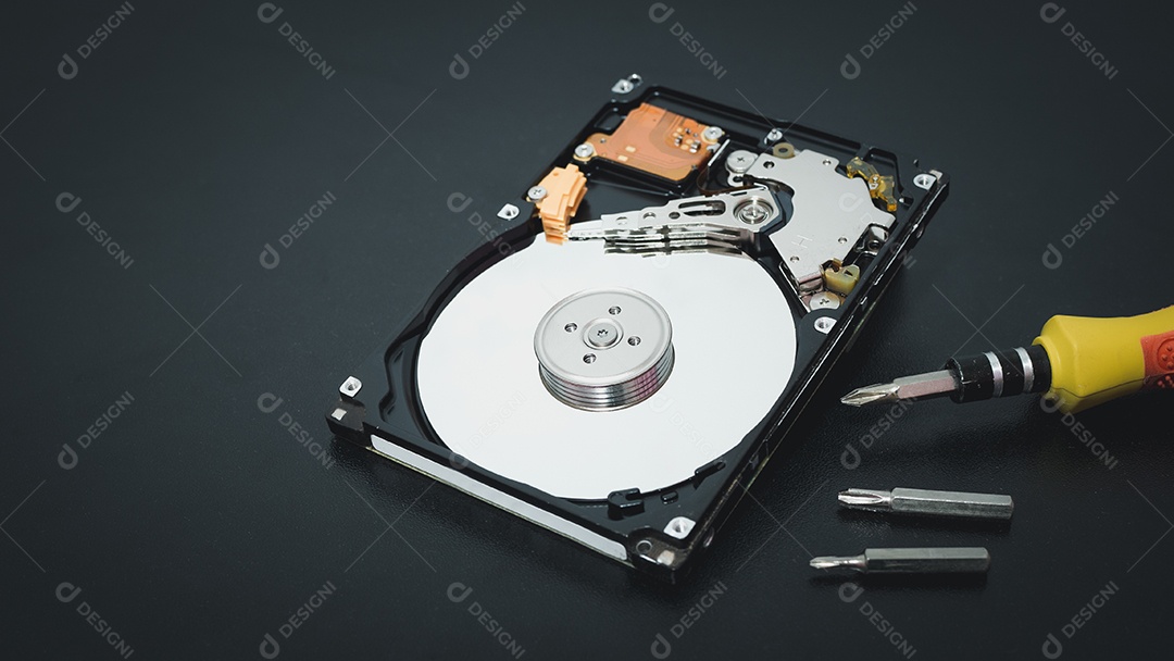 Unidade de disco rígido aberta desmontada HDD de computador ou laptop encontra-se na superfície fosca escura.
