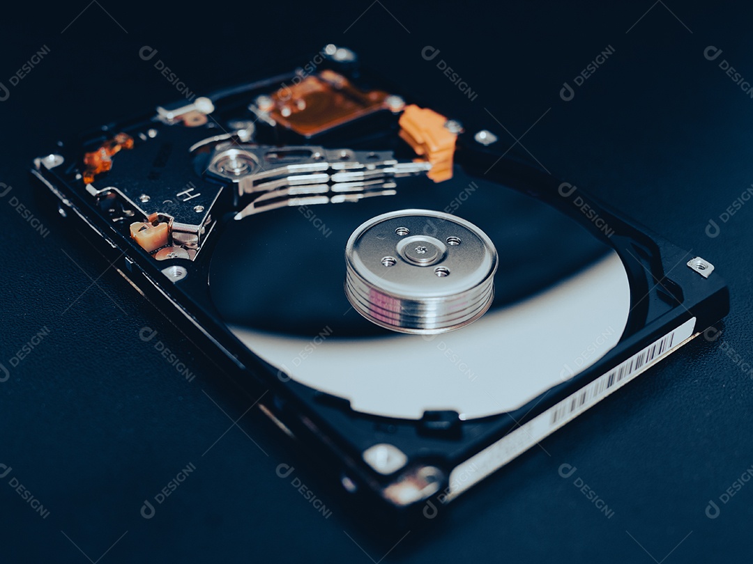 Unidade de disco rígido aberta desmontada HDD de computador ou laptop encontra-se na superfície fosca escura.
