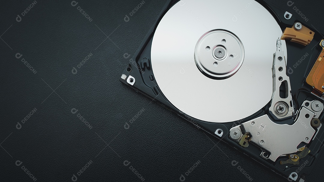 Unidade de disco rígido aberta desmontada HDD de computador ou laptop encontra-se na superfície fosca escura.