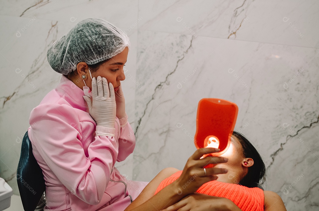 Dentista sobre seu consultorio odontológico atendendo seu paciente