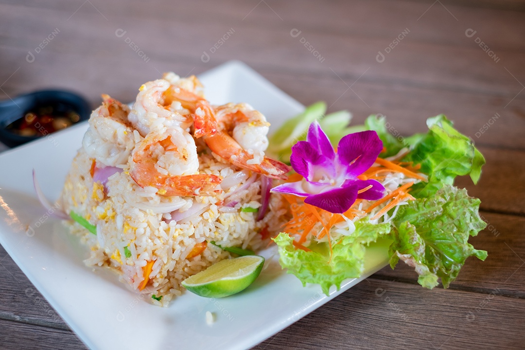 Arroz frito com camarão no prato branco na mesa de madeira, comida tailandesa