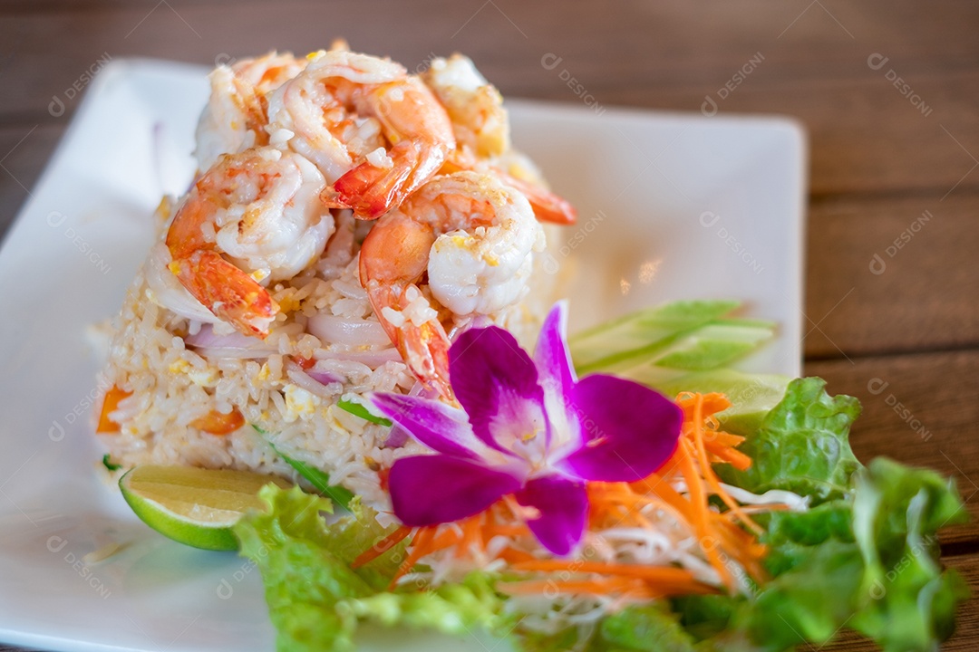 Arroz frito com camarão no prato branco na mesa de madeira, comida tailandesa