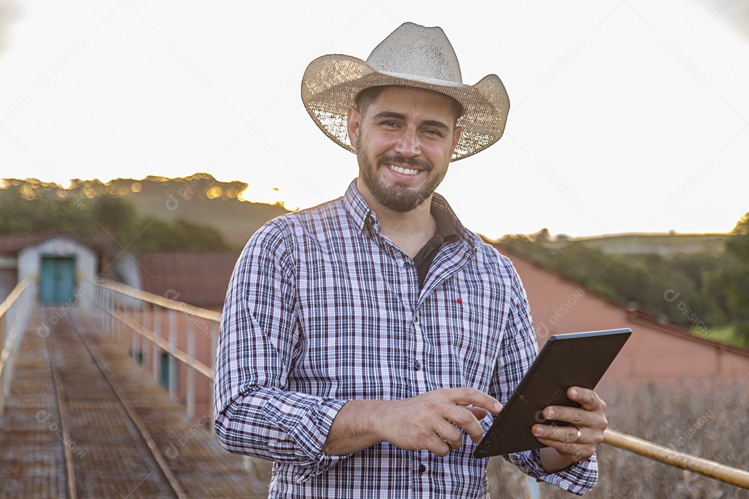Homem jovem agricultor segurando tablet laptop