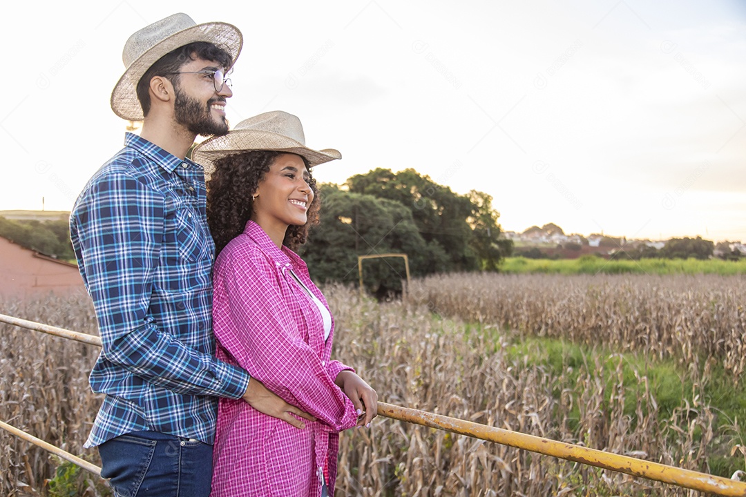 Casal feliz e sorridente sobre plantação