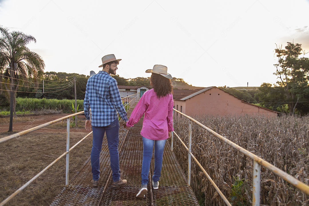 Casal feliz e sorridente sobre plantação
