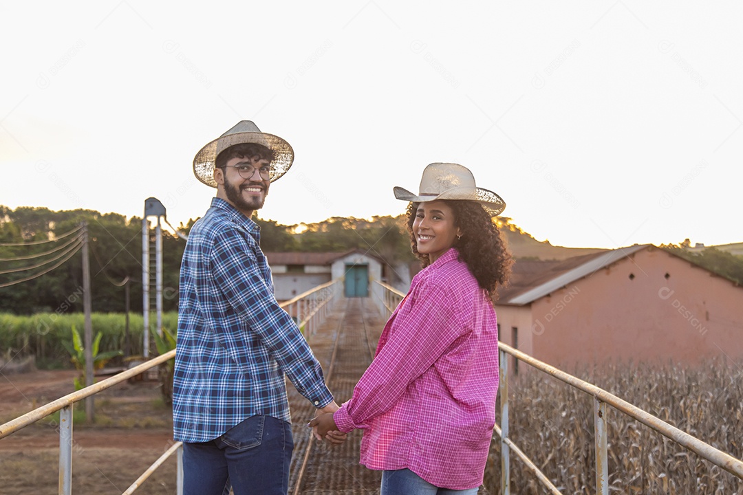 Casal feliz e sorridente sobre plantação