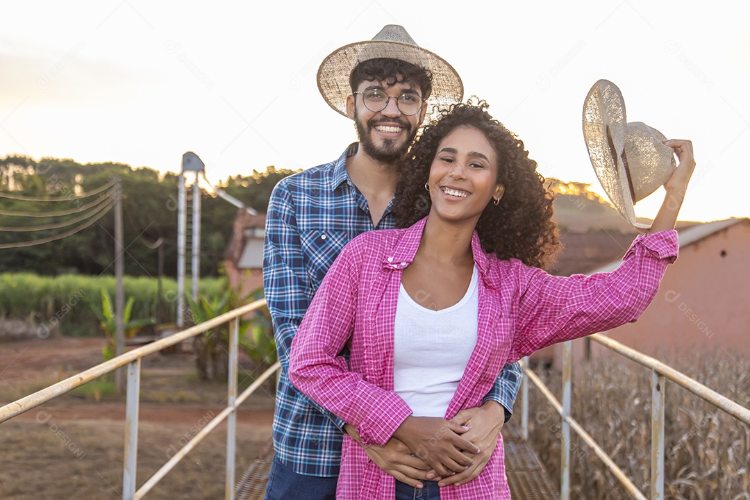 Casal feliz e sorridente sobre plantação