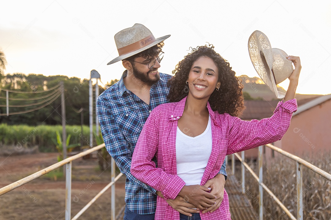 Casal feliz e sorridente sobre plantação