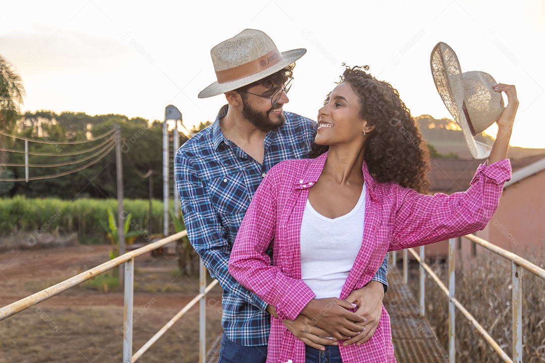 Casal feliz e sorridente sobre plantação