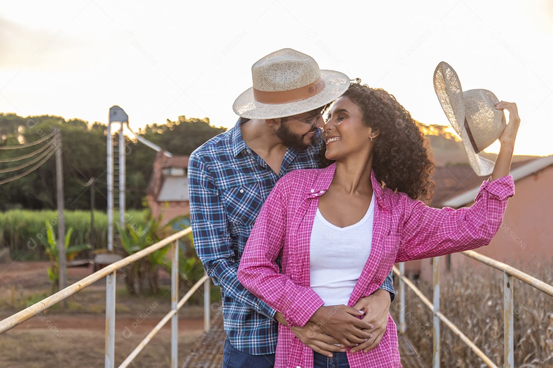 Casal feliz e sorridente sobre plantação