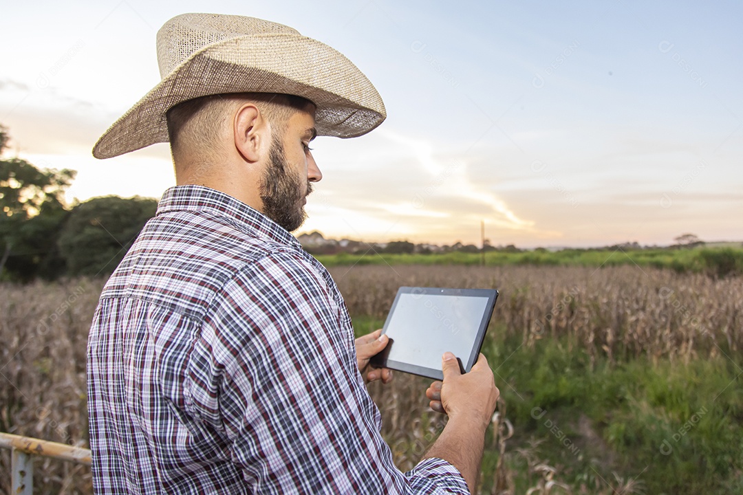Homem jovem agricultor segurando tablet laptop