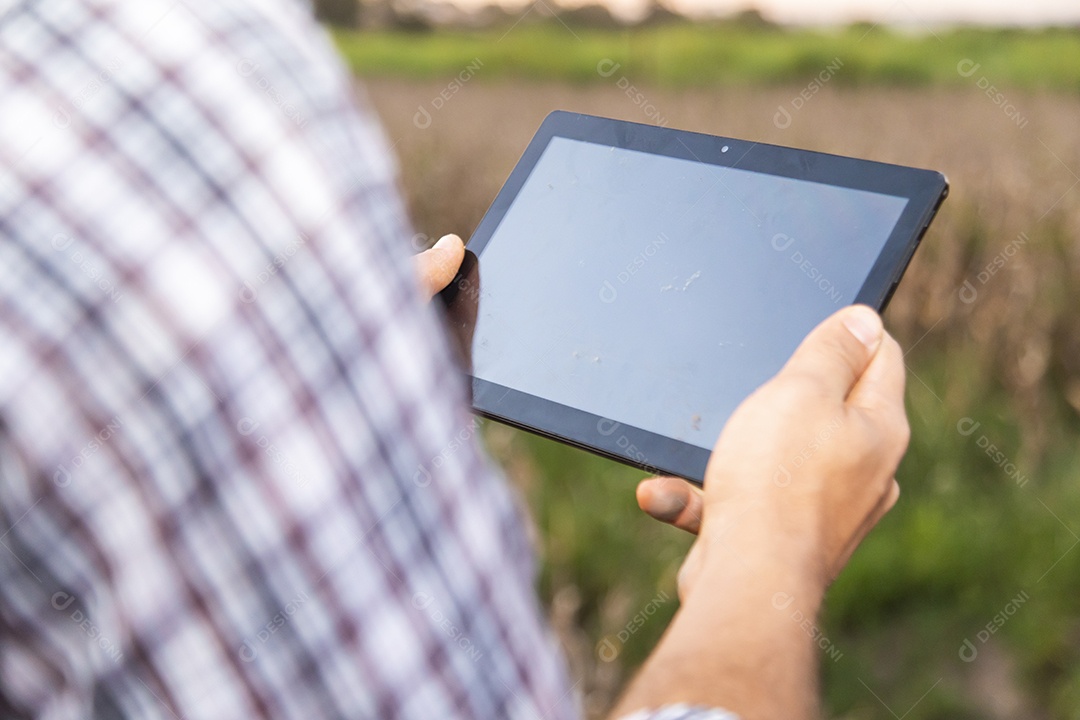 Homem jovem agricultor segurando tablet laptop