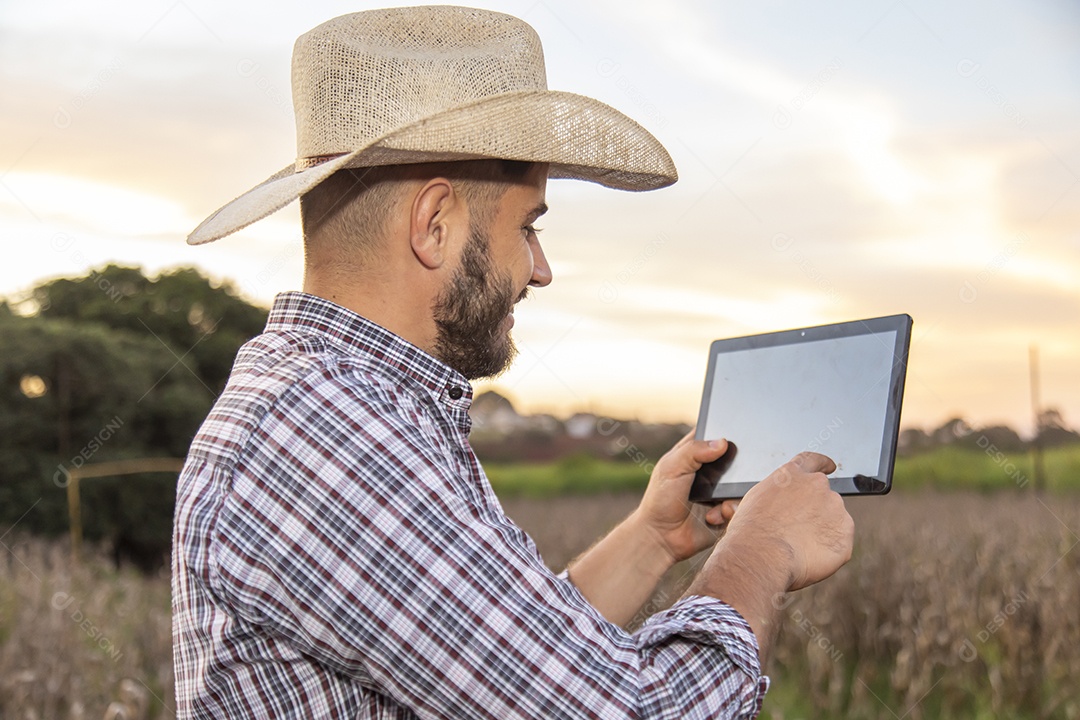 Homem jovem agricultor segurando tablet laptop