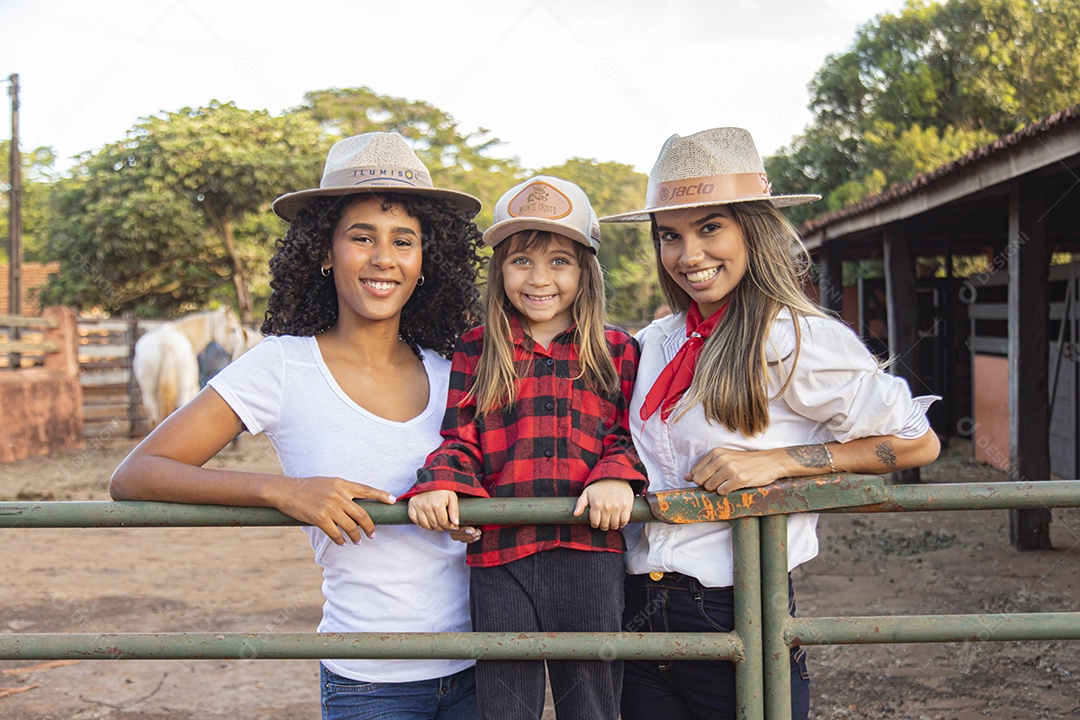 Lindas mulheres ao lado de criança sobre uma fazenda