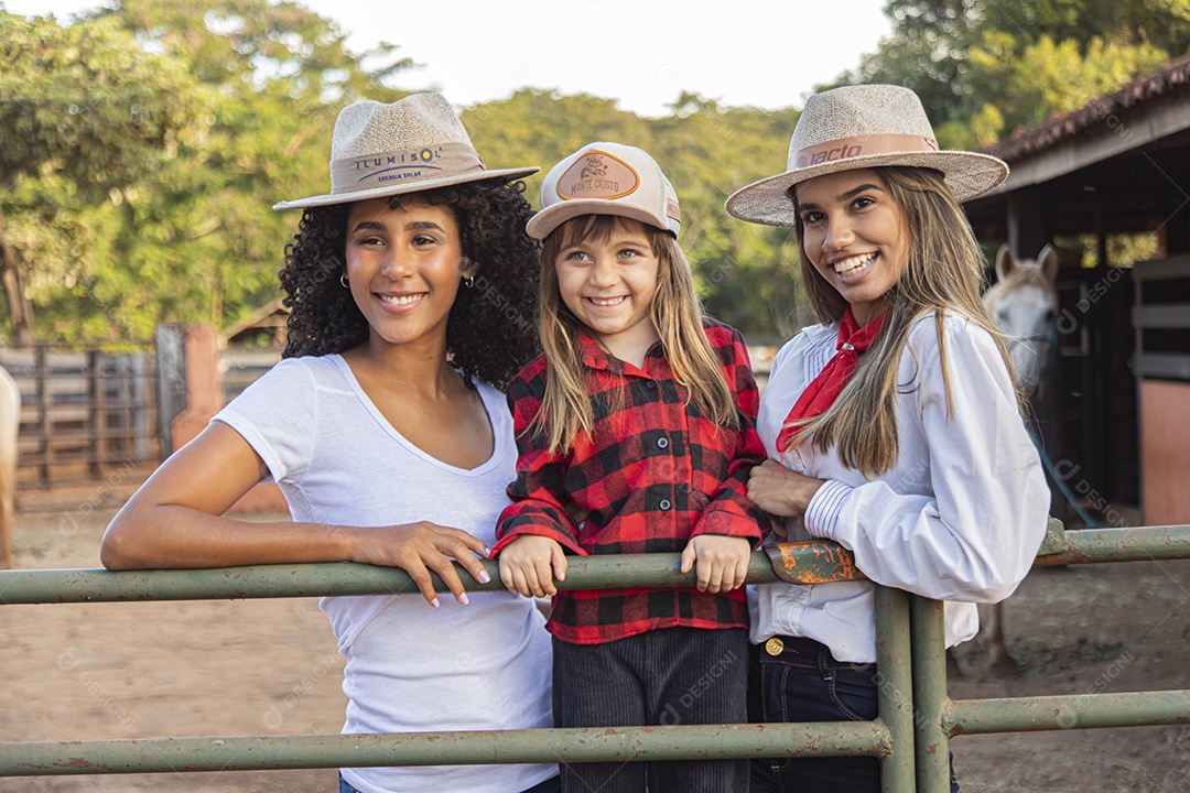 Lindas mulheres ao lado de criança sobre uma fazenda