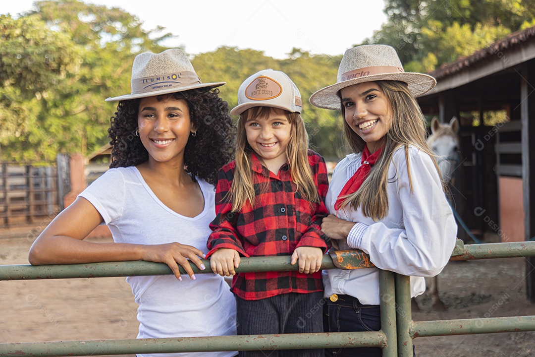 Lindas mulheres ao lado de criança sobre uma fazenda