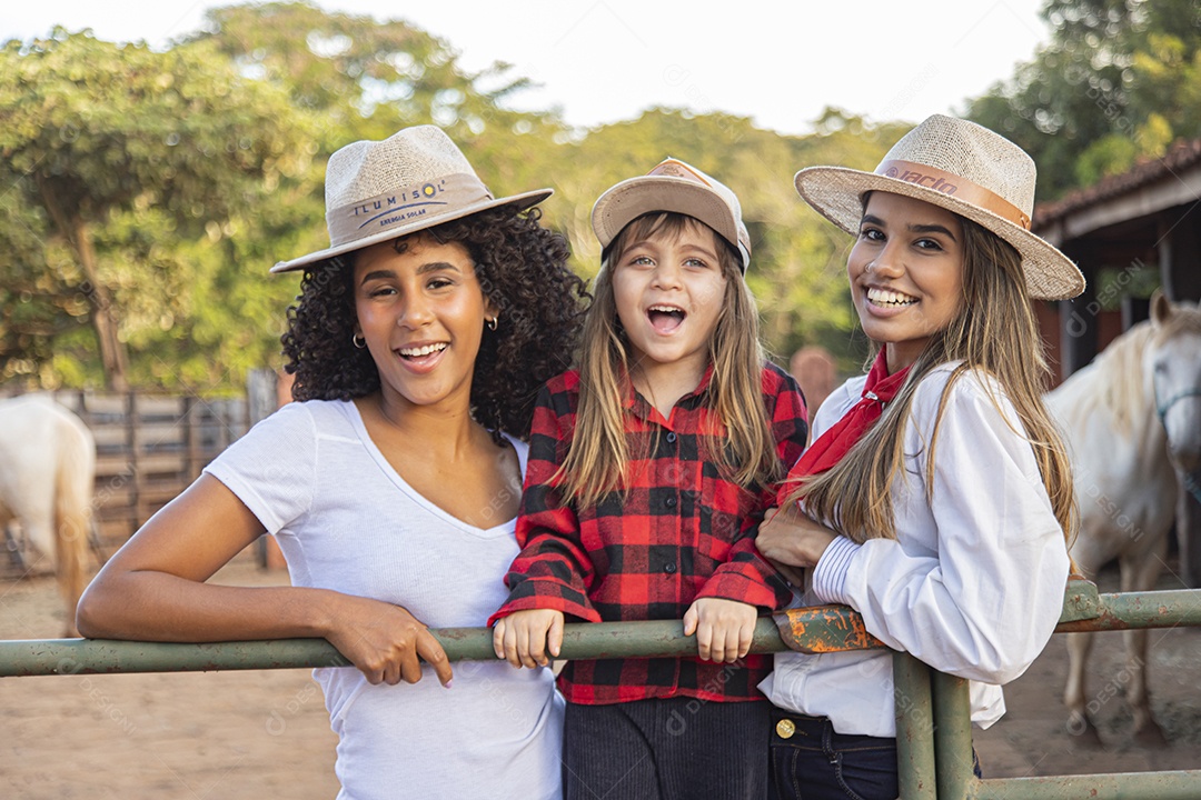 Lindas mulheres ao lado de criança sobre uma fazenda