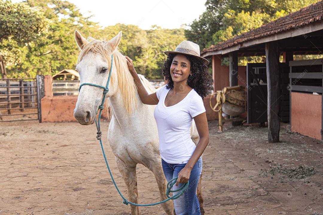 Menina jovem sobre uma fazenda ao lado de seu cavalo