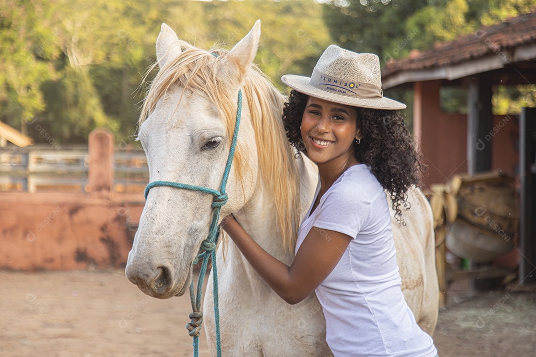 Menina jovem sobre uma fazenda ao lado de seu cavalo