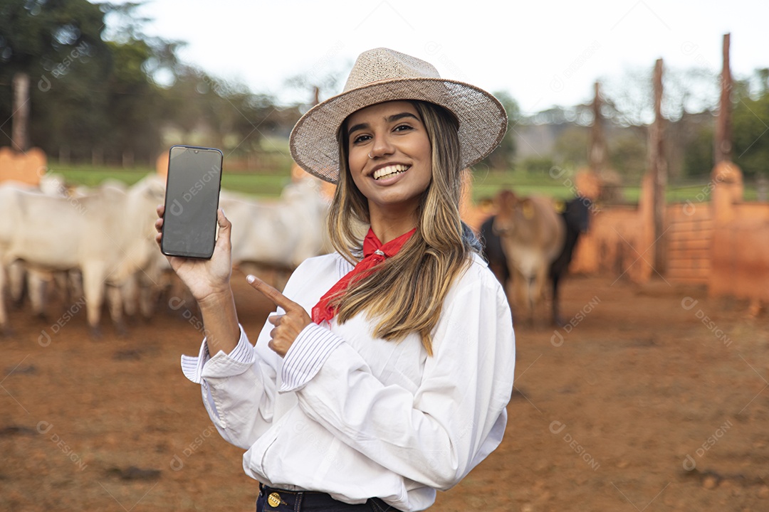 Mulher agricultora sobre fazenda segurando celular smartphone