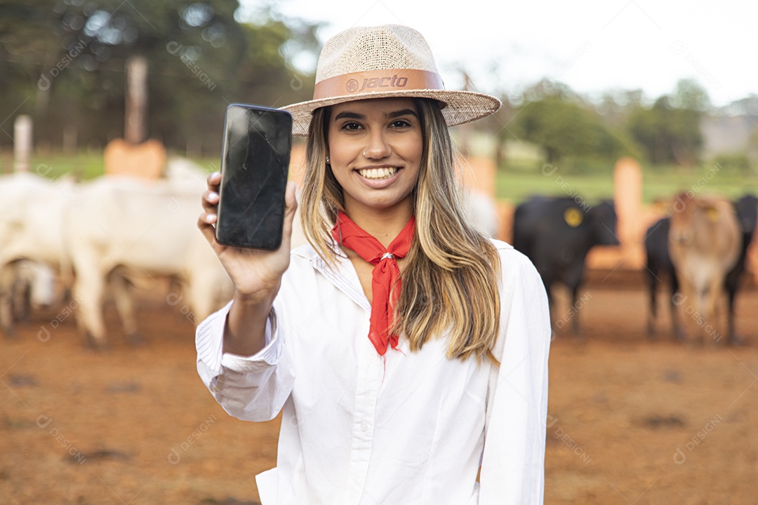 Mulher agricultora sobre fazenda segurando celular smartphone