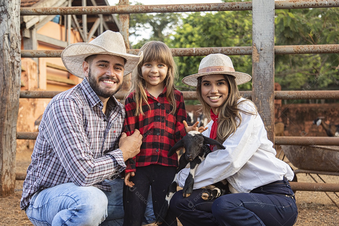 Pai e mãe agricultores ao lado de sua filha sobre uma fazenda