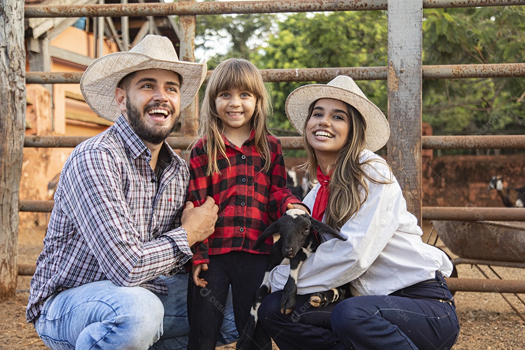 Pai e mãe agricultores ao lado de sua filha sobre uma fazenda