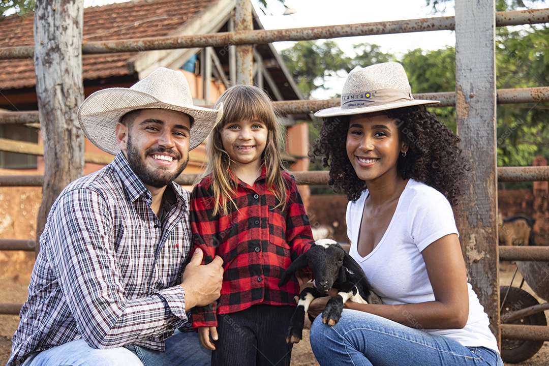 Pai e mãe agricultores ao lado de sua filha sobre uma fazenda