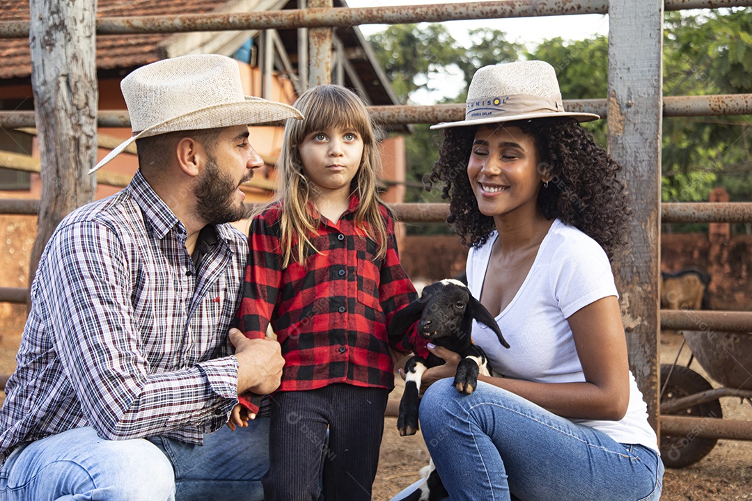 Pai e mãe agricultores ao lado de sua filha sobre uma fazenda