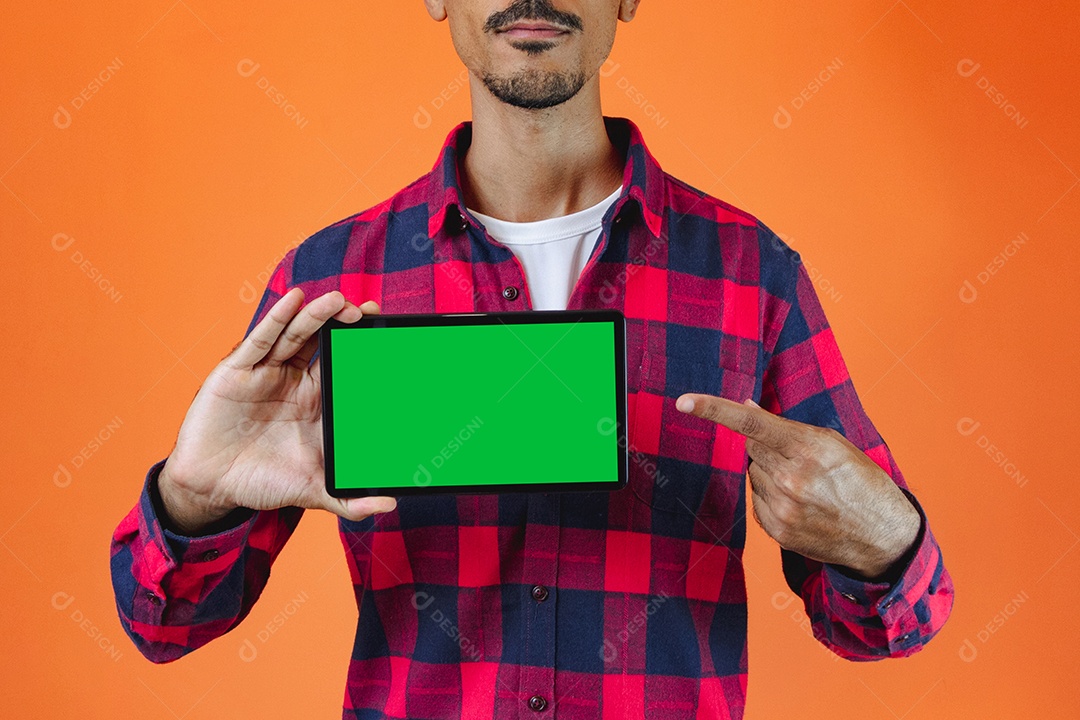 Festa Junina. Homem negro com roupa segurando um celular isolado em fundo laranja.