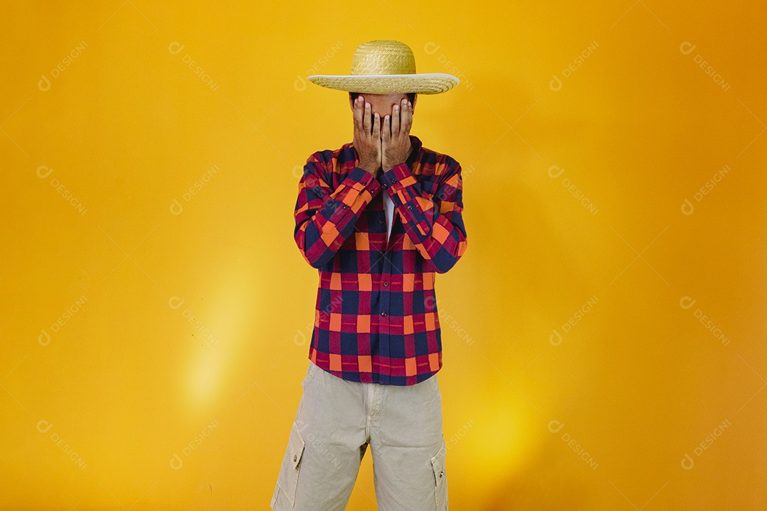 Homem negro vestindo roupas tradicionais para a Festa Junina isolada em fundo amarelo