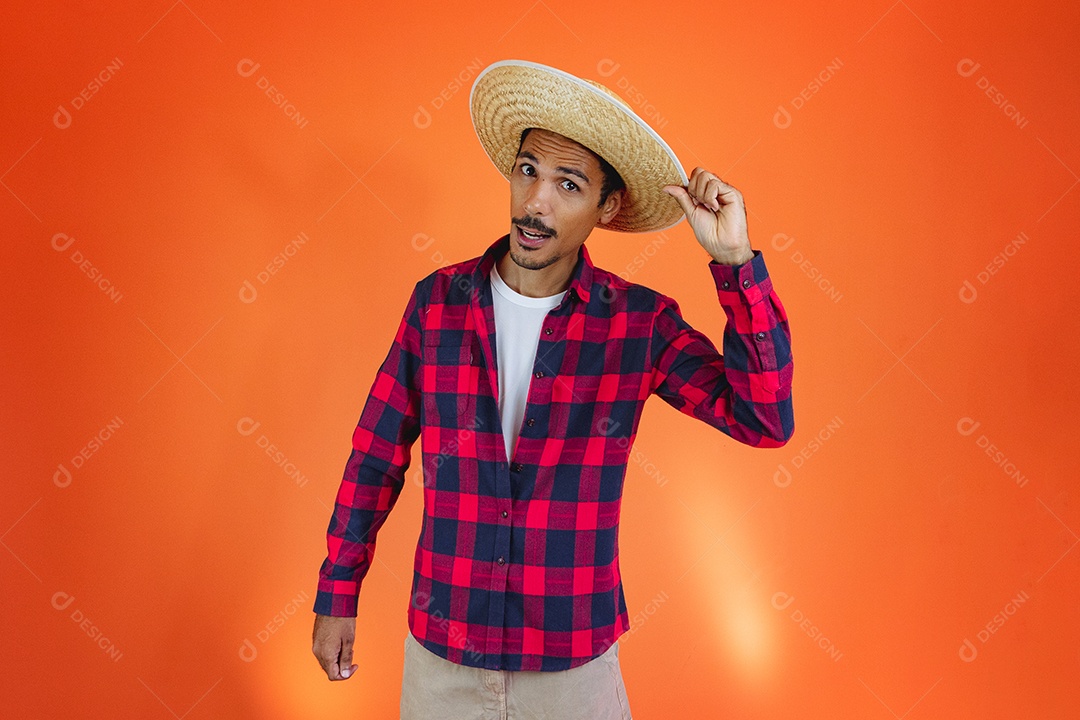 Festa Junina. Homem negro com roupa apontando isolado em fundo laranja.