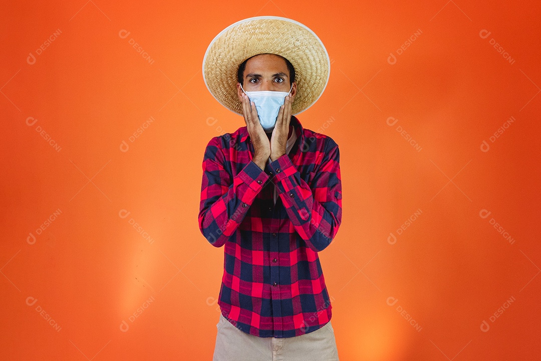 Festa Junina. Homem negro com roupa apontando isolado em fundo laranja.