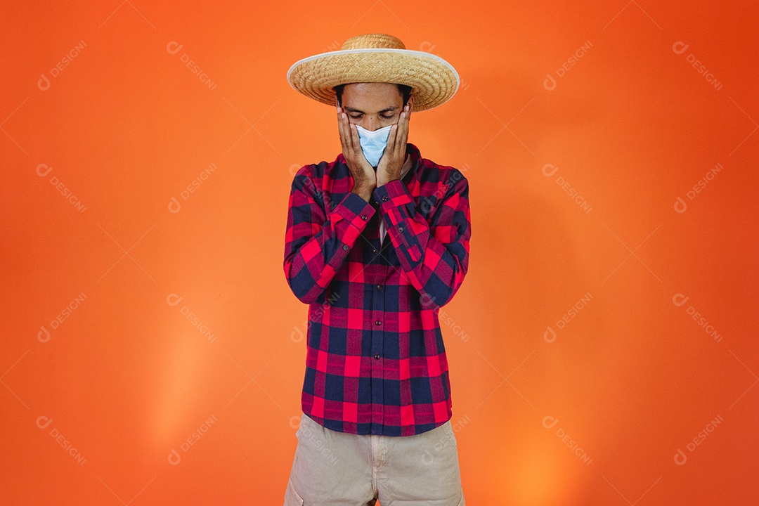 Festa Junina. Homem negro com roupa apontando isolado em fundo laranja.