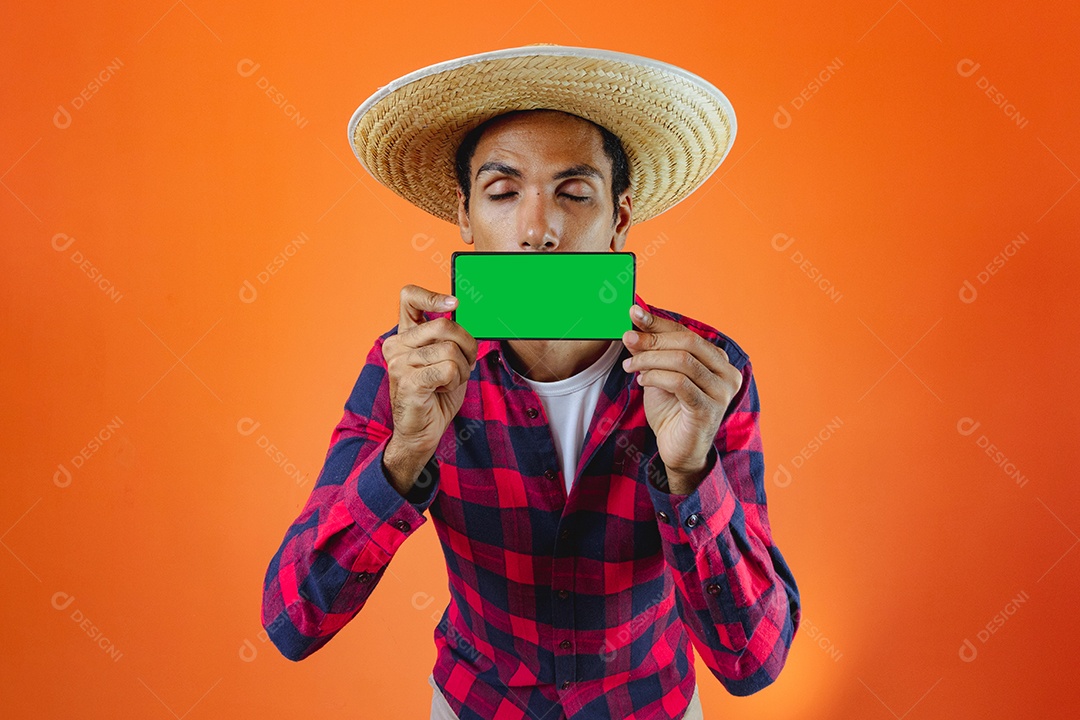 Festa Junina. Homem negro com roupa apontando isolado em fundo laranja.