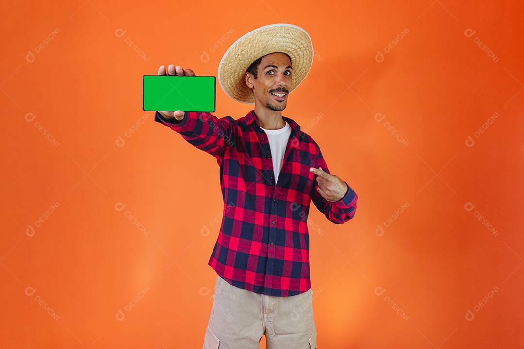 Festa Junina. Homem negro com roupa apontando isolado em fundo laranja.