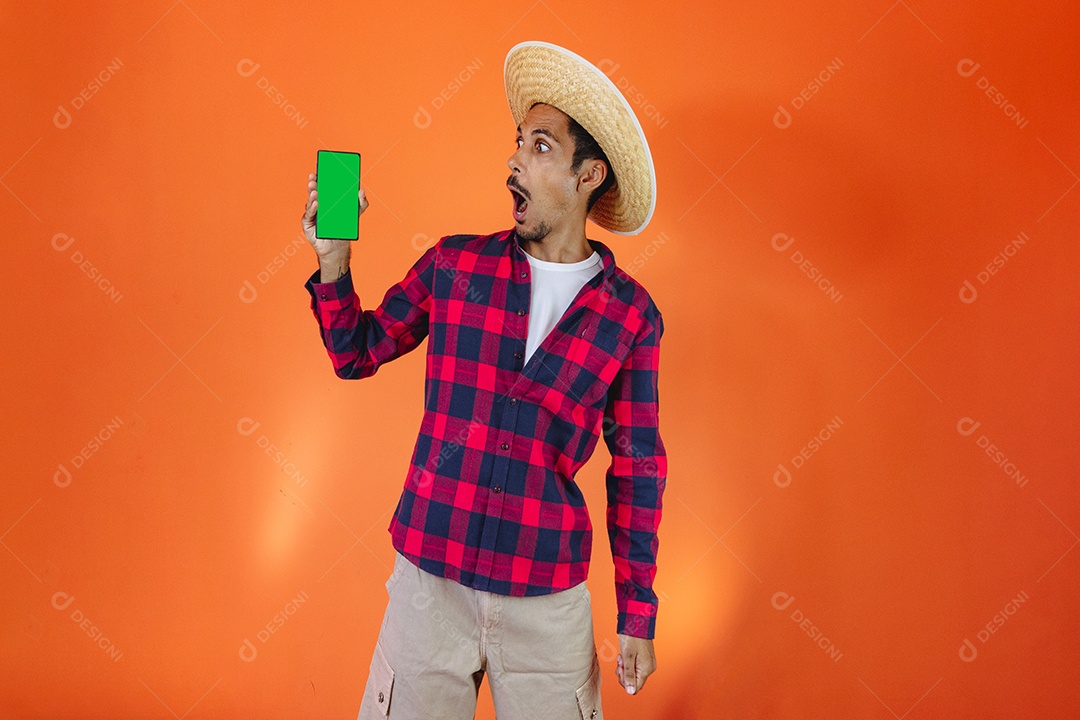 Festa Junina. Homem negro com roupa apontando isolado em fundo laranja.