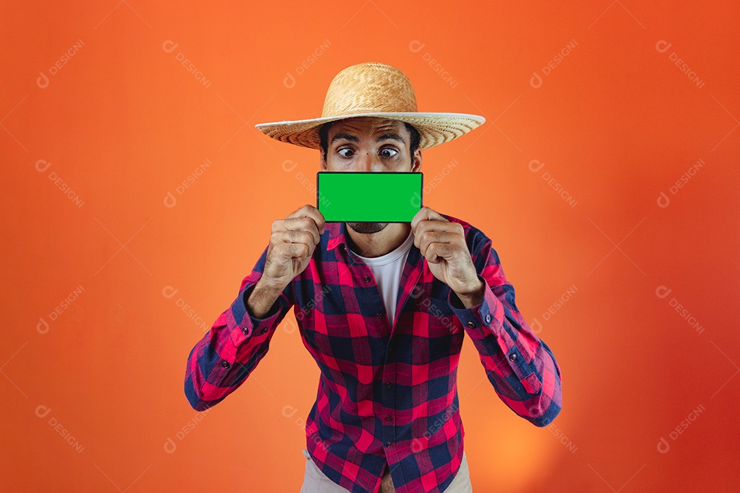 Festa Junina. Homem negro com roupa apontando isolado em fundo laranja.