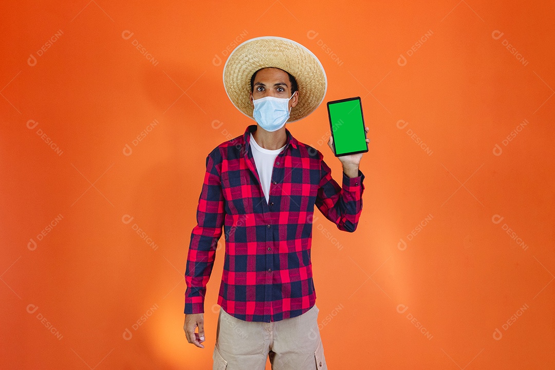 Festa Junina. Homem negro com roupa apontando isolado em fundo laranja.