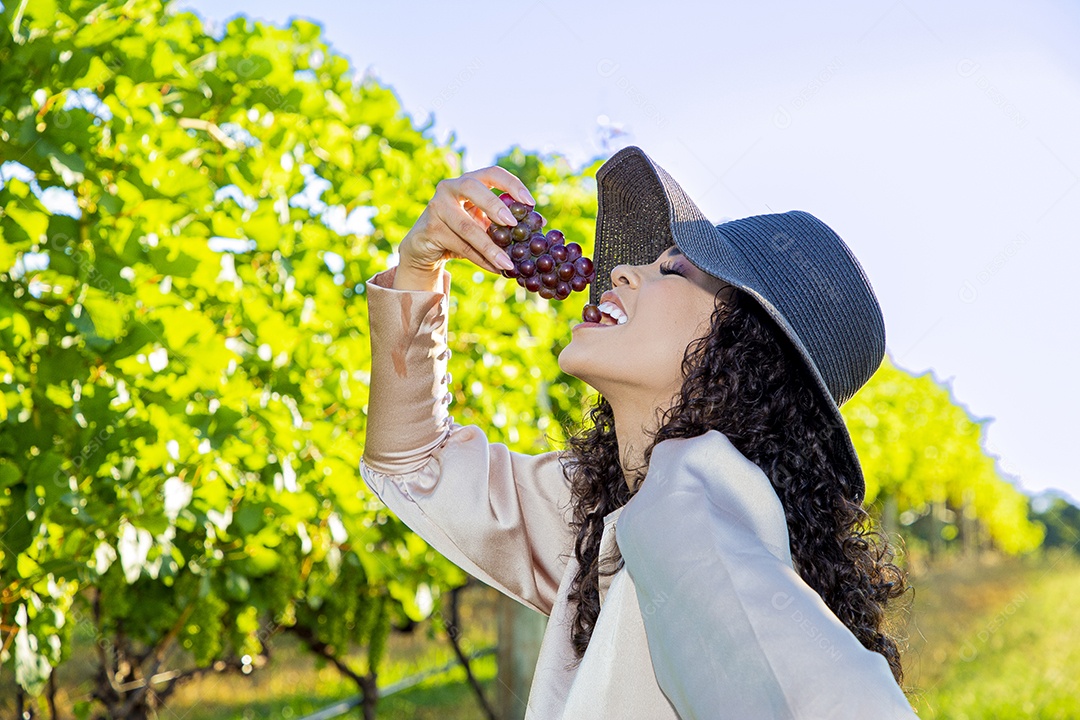 Mulher jovem sobre plantio de uvas