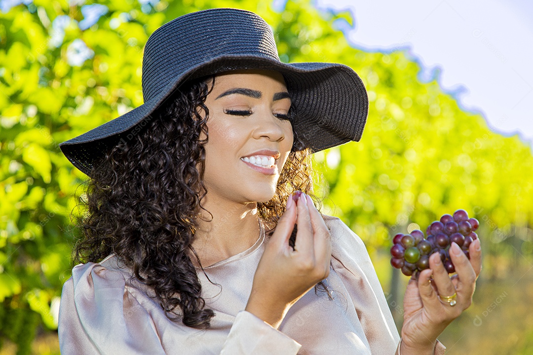 Mulher jovem sobre plantio de uvas