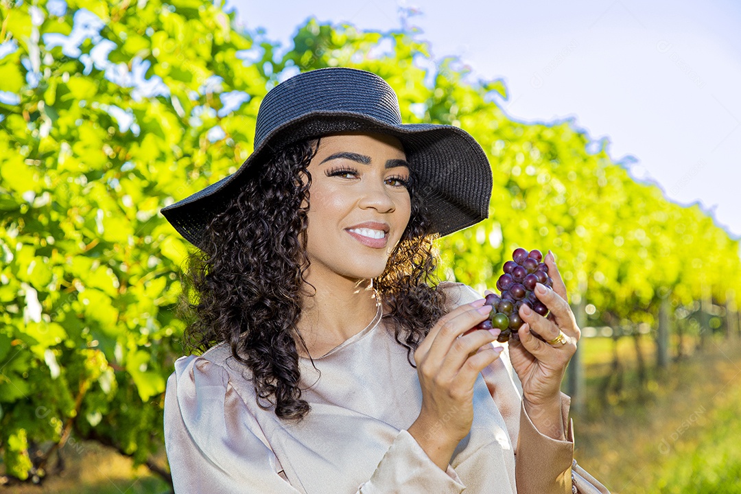 Mulher jovem sobre plantio de uvas