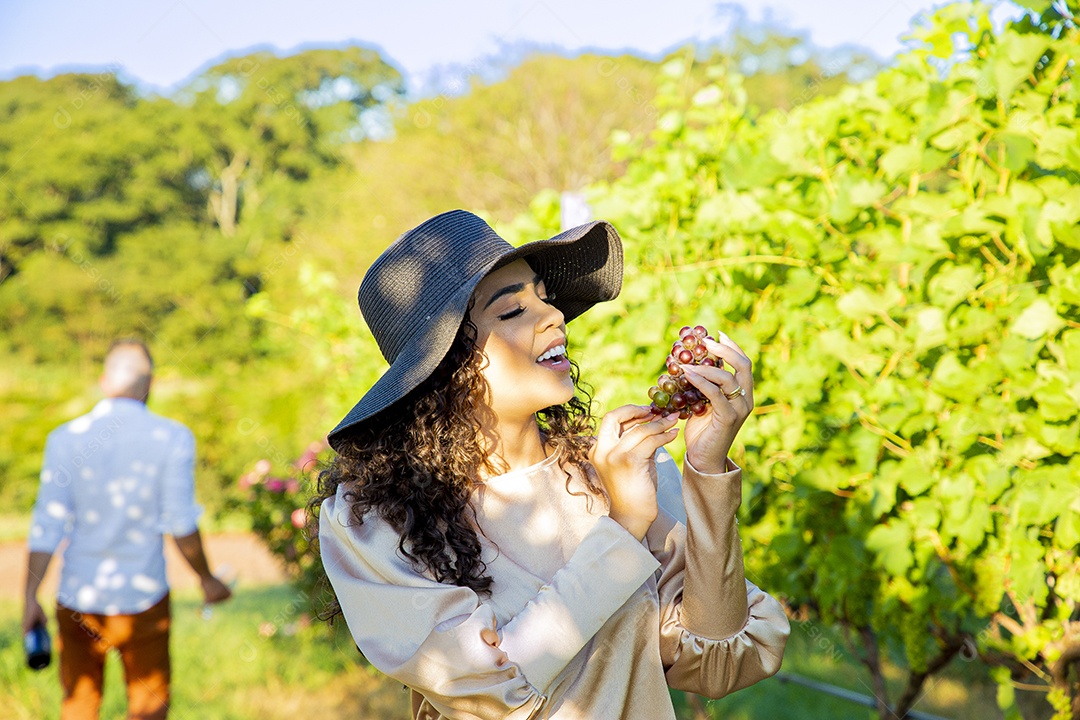 Mulher jovem sobre plantio de uvas