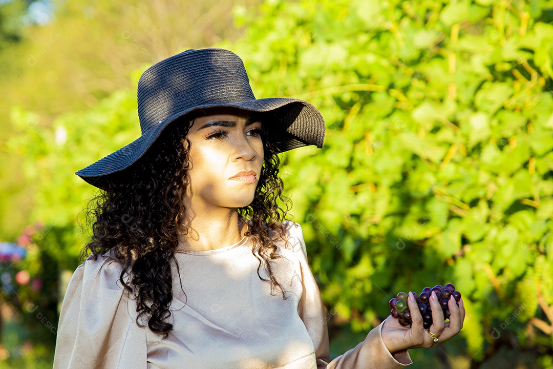 Mulher jovem sobre plantio de uvas
